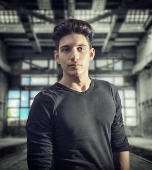 A man in a black shirt standing in an empty room