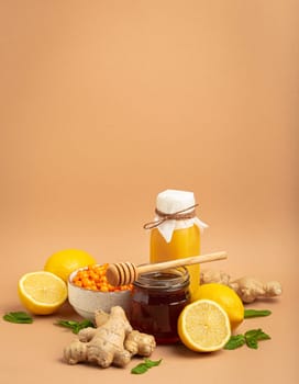 Composition with detox drink, sea buckthorn berries, lemons, mint, ginger, honey in glass jar. Food for immunity stimulation and against flu. Healthy natural remedies to boost immune system.