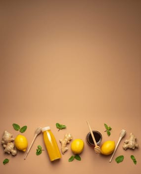 Composition with detox drink, lemons, mint, ginger, honey in glass jar, honey wooden dippers top view. Food for immunity stimulation and against flu. Healthy natural remedies to boost immune system.