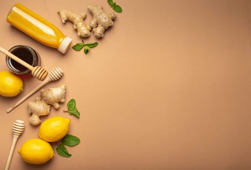 Orange detox drink, lemons, mint, ginger, honey in glass jar, honey wooden dippers top view. Food for immunity stimulation and against flu. Healthy remedies to boost immune system, copy space.