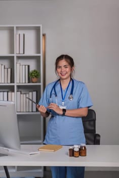 Young asian 30s female medic in uniform holding clipboard in doctor's office.