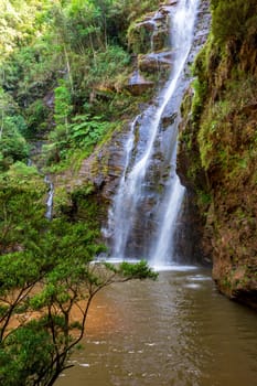 Beautiful waterfall among the dense vegetation of rainfoest and rocks in the state of Minas Gerais, Brazil