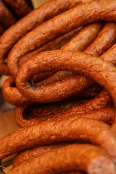 There are raw smoked sausages on the market. Close-up. Vertical frame.