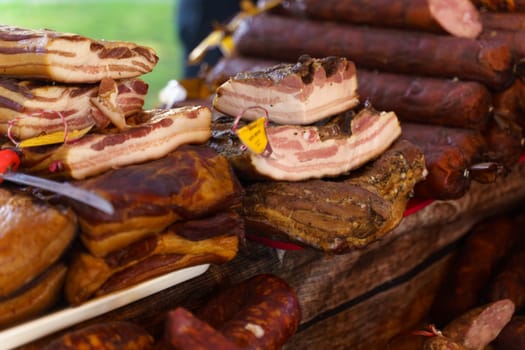 Large pieces of smoked brisket and sausage lie on the counter. Selective sharpening.