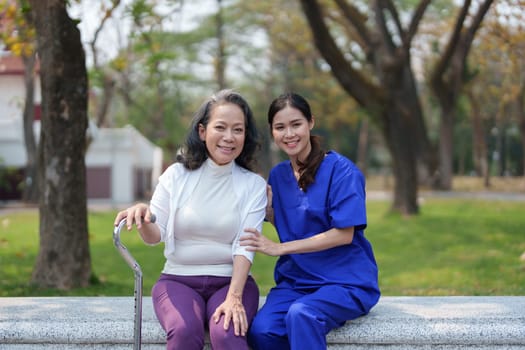 Patient care, female care, young Asian women are taking care of the elderly, providing crutches and walking for patients, and exercising their legs and knees in the park parks