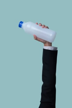 Businessman's hand holding plastic bottle on isolated background. Eco-business recycle waste policy in corporate responsibility. Reuse, reduce and recycle for sustainability environment. Quaint