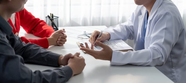 Couple attend fertility consultation with gynecologist at hospital as part family planning care for pregnancy. Loving husband and wife support each other through the doctor appointment. Panorama Rigid