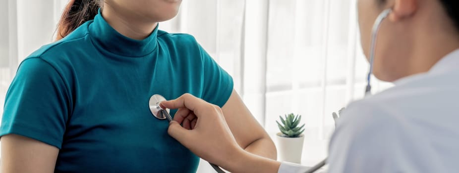 Patient attend doctor's appointment at clinic or hospital office. Doctor examining and diagnosis symptoms while checking the patient's pulse with stethoscope. Panorama Rigid