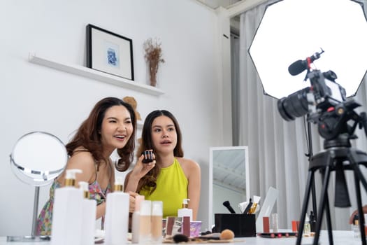 Woman influencer shoot live streaming vlog video review makeup uttermost social media or blog. Happy young girl with cosmetics studio lighting for marketing recording session broadcasting online.