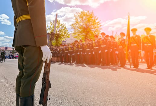 Soldiers stand in line with rifles. Guard of honor shoulder to shoulder during the parade.