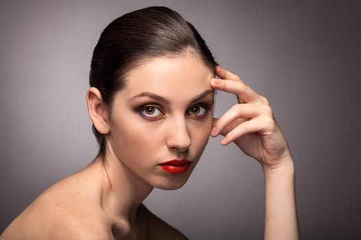 Beauty fashion girl. Portrait of beautiful young woman with fresh clean skin on grey background