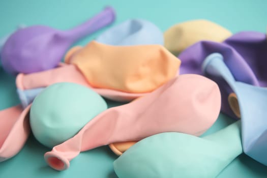 A vibrant and colorful collection of pastel latex balloons beautifully arranged on a teal surface