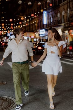 A charming couple leisurely strolls through a bustling city street, which is beautifully adorned with vibrant lanterns