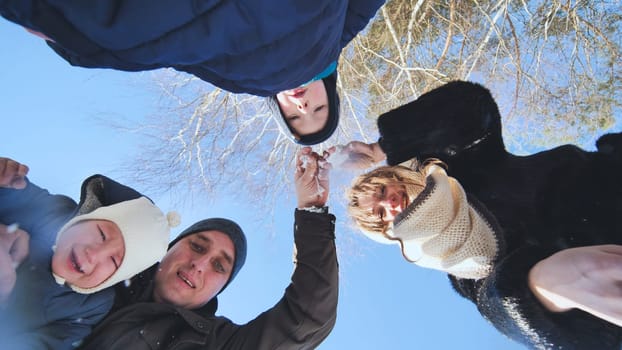 Happy family enjoying a winter day outdoors, playing in the snow and sharing smiles, surrounded by nature's beauty and bright blue skies