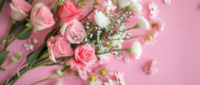 An elegant assortment of roses and baby's breath flowers, displayed on a vivid pink background, conveys a sense of freshness and beauty