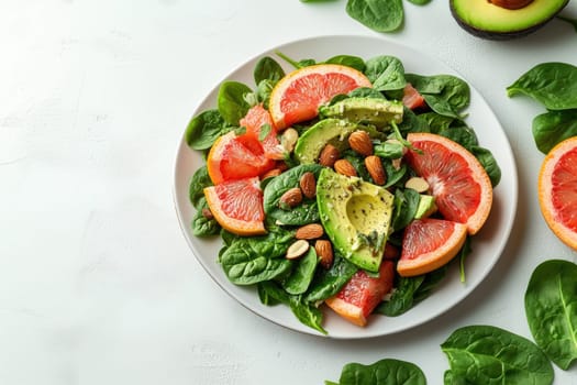A vibrant salad features fresh spinach topped with sliced grapefruit, avocado, and almonds, creating a healthy dish rich in flavors and textures.