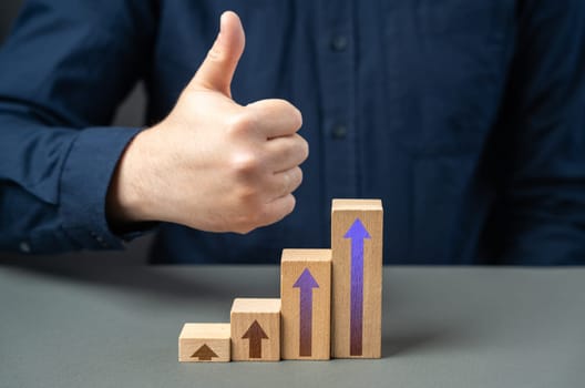 A man shows a thumbs up from a success graph. Successful investments. Income and economic development. Optimistic forecast. Entrepreneurship.