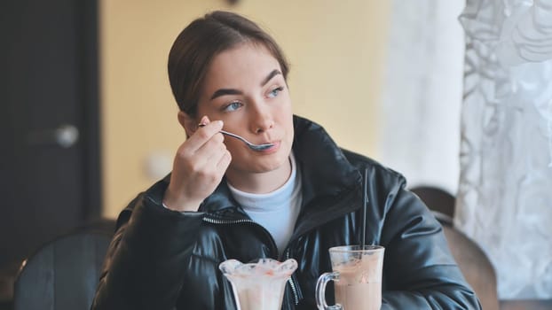 Customer savoring a delicious dessert and refreshing iced coffee, immersing in a relaxing cafe atmosphere filled with warmth and comfort