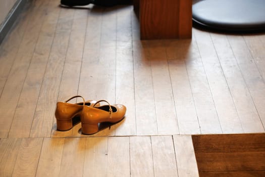 A pair of stylish brown shoes carefully arranged on a beautifully polished wooden floor