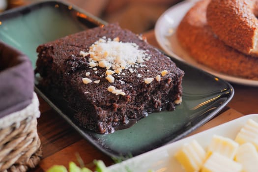A deliciously rich slice of chocolate cake, elegantly topped with a sprinkle of coconut flakes