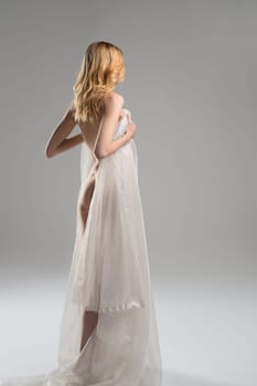 Slim sexy blonde wrapped in white cloth rearview