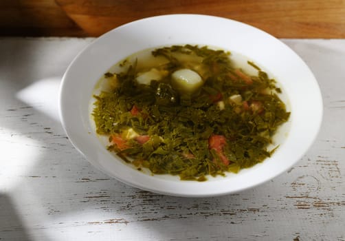 Freshly prepared soup loaded with savory greens and vegetables, perfect for a cozy meal at home on a chilly day.