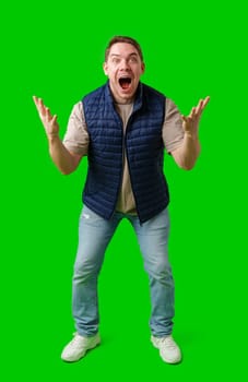 Man celebrating with raised fists in front of a bright green background in studio