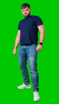 Man expressing confusion with crossed arms in front of a bright green background during a casual moment
