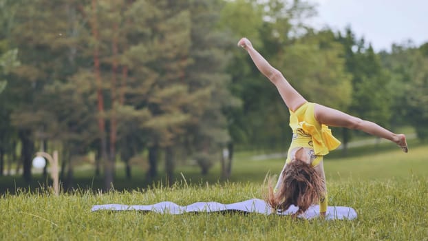 Young gymnast displays impressive flexibility and balance, executing a perfect cartwheel on a mat amidst the serene beauty of a park