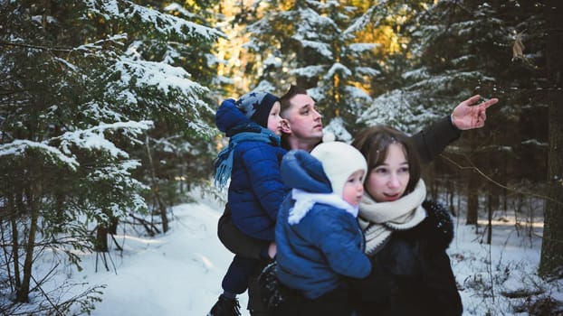 Parents carrying their children while walking in a snowy forest, enjoying a winter day together