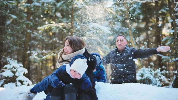 Family enjoying a playful winter day in snowy woods, joyfully throwing snow in the air and creating cherished memories together