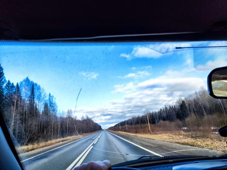 Car salon, windshield, and landscape through damaged windshield. View from seat of driver on nature. The danger of driving faulty car