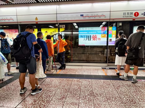 Hong Kong, China - April 09, 2024 - Commuters gather at a Hong Kong subway platform, awaiting the arrival of a train during peak travel time.