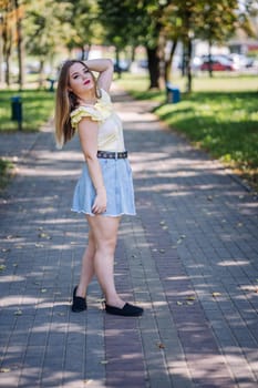 Fashionable young woman posing confidently in a vibrant park, soaking up the sun on a cheerful summer day surrounded by nature