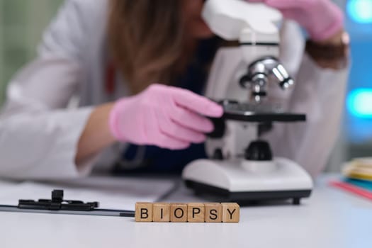 Carefully examining biopsy samples through a microscope within a contemporary laboratory environment