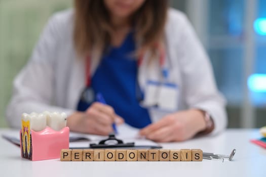 A qualified dentist studies periodontosis extensively while writing detailed notes regarding patient care and treatment