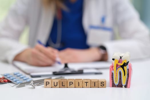 A knowledgeable dental professional discusses the condition of pulpitis while examining a detailed tooth model