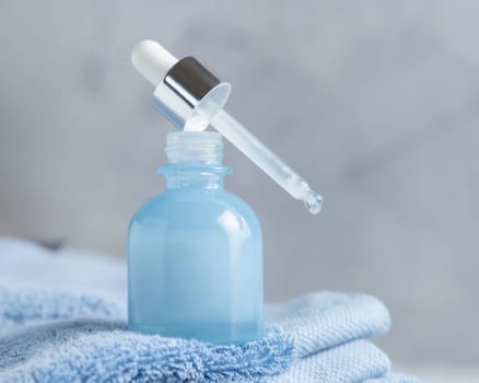 White cream squeeze tube on white marble table against green plant and cosmetic bottles in bathroom, close up, packaging mockup. Natural product for face care