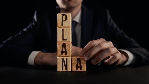 the hand highlights the letter A from the plan