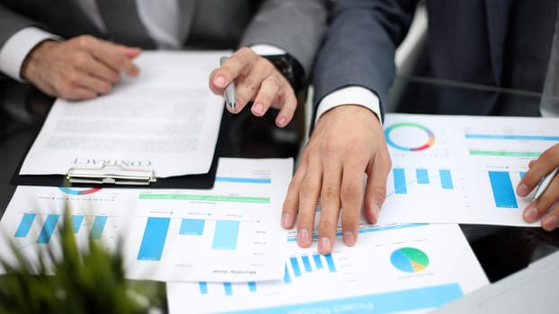 Businessman working at office desk, he is building a growing financial graph using wooden toy blocks. successful business concept