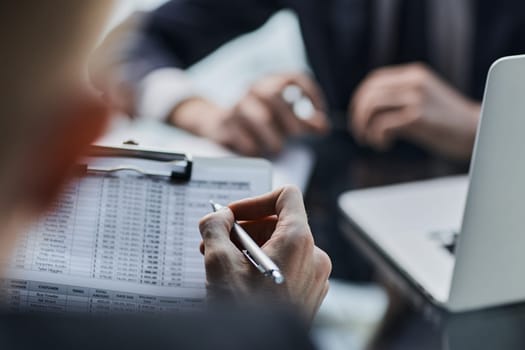 Close-up. Businessman looking at financial report and making notes with a pen in it