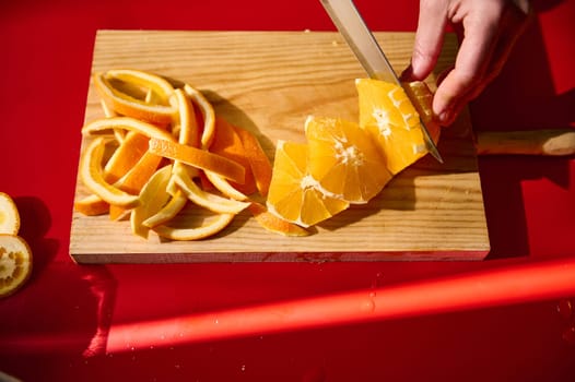 Fresh orange slices and peel arranged on a wooden cutting board, illuminated by sunlight, highlighting the vibrant colors and textures of this fruit. Ideal for concepts related to fresh food and preparation.