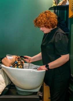 The client's hair is washed in a beauty salon. The client has curlers on his head. The hair is curled so that the hair is curly and wavy.