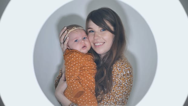 Radiant mother cradling newborn daughter within soft circular glow, highlighting maternal warmth and intimate connection