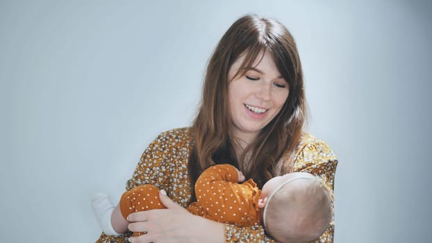 Happy mother holding her peacefully sleeping newborn baby girl, cherishing moments of motherhood and nurturing love at home