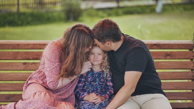 Happy family enjoying quality time together, sharing laughter and affection on a wooden swing in their lush backyard garden