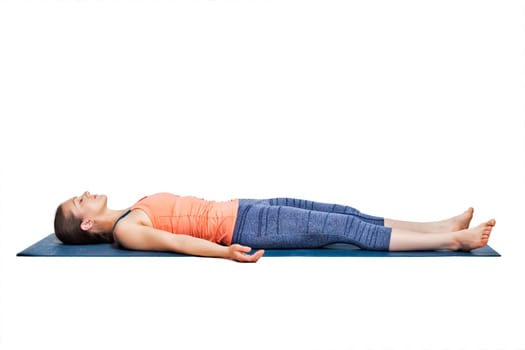 Beautiful sporty fit yogini woman relaxes in yoga asana Savasana - corpse pose in studio