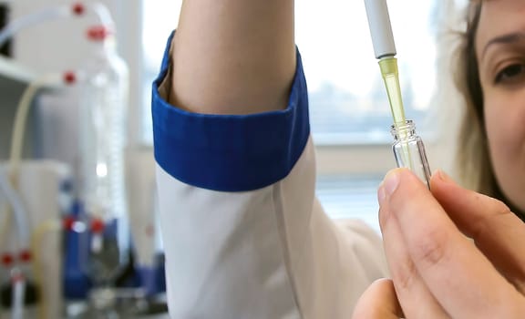 A female laboratory assistant uses a special pipette to work with biomaterial. Analysis of liquids.