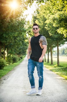 A man standing on a dirt road with trees in the background. Photo of a man standing on a dirt road surrounded by trees