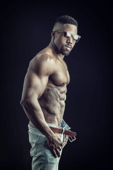 A shirtless man with no shirt on posing for a picture. Photo of a muscular African American man posing shirtless for a photo on black background